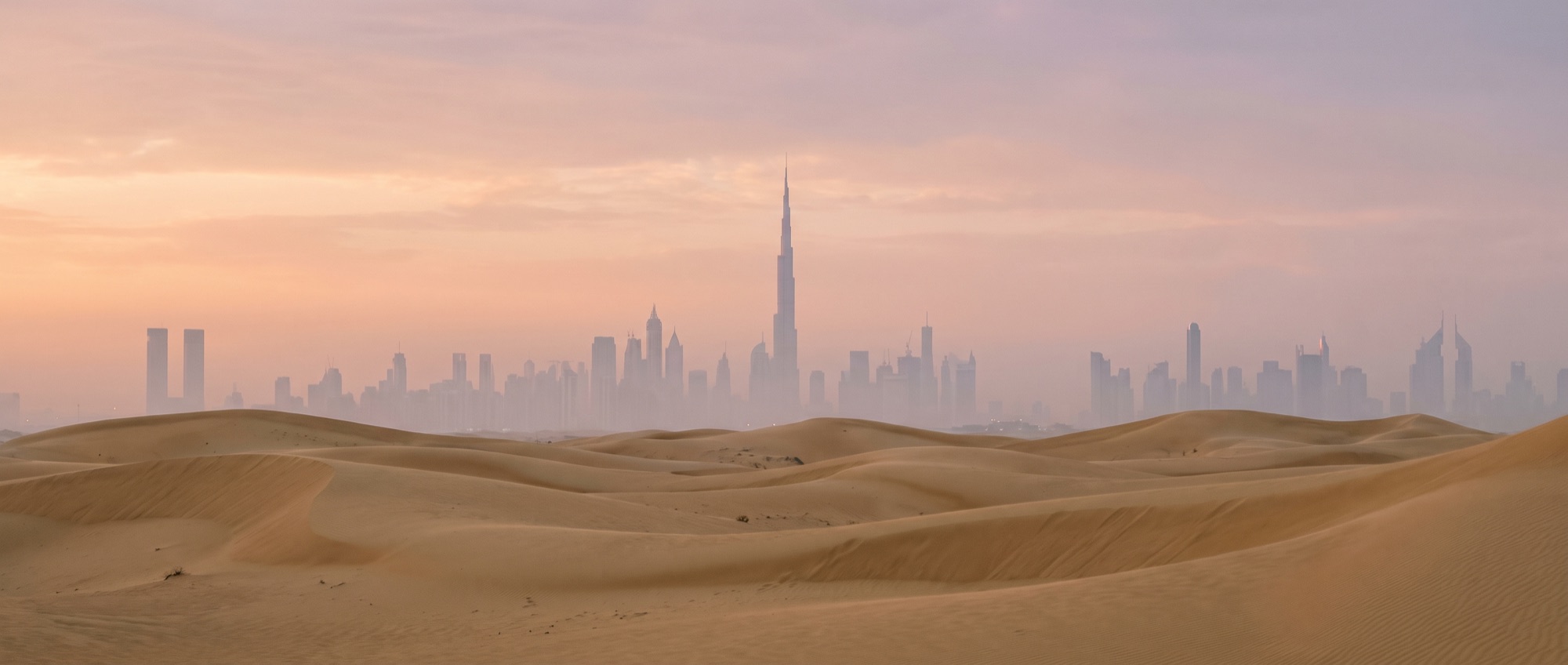 Dunes et skyline de Dubaï à l'aube (image d'ambiance)